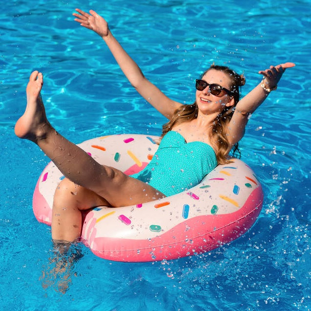 Pink inflatable inner tube. Designed to look like a frosted donut with multi-colored sprinkles.
