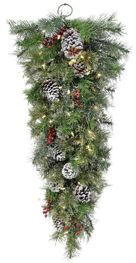 This is a triangular shaped Christmas decoration designed to look like green foliage accented with lights, red berries, pine cones and flecks of fake snow.