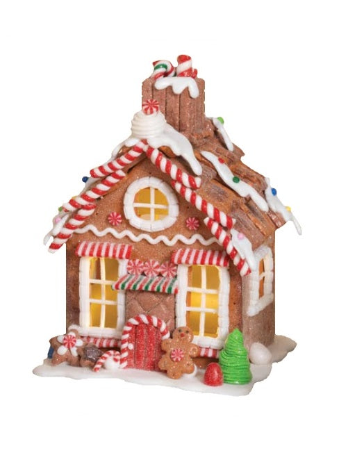 Tabletop decoration designed to look like a decorated gingerbread house. Features frosting, peppermint, gummy and sugar accents.