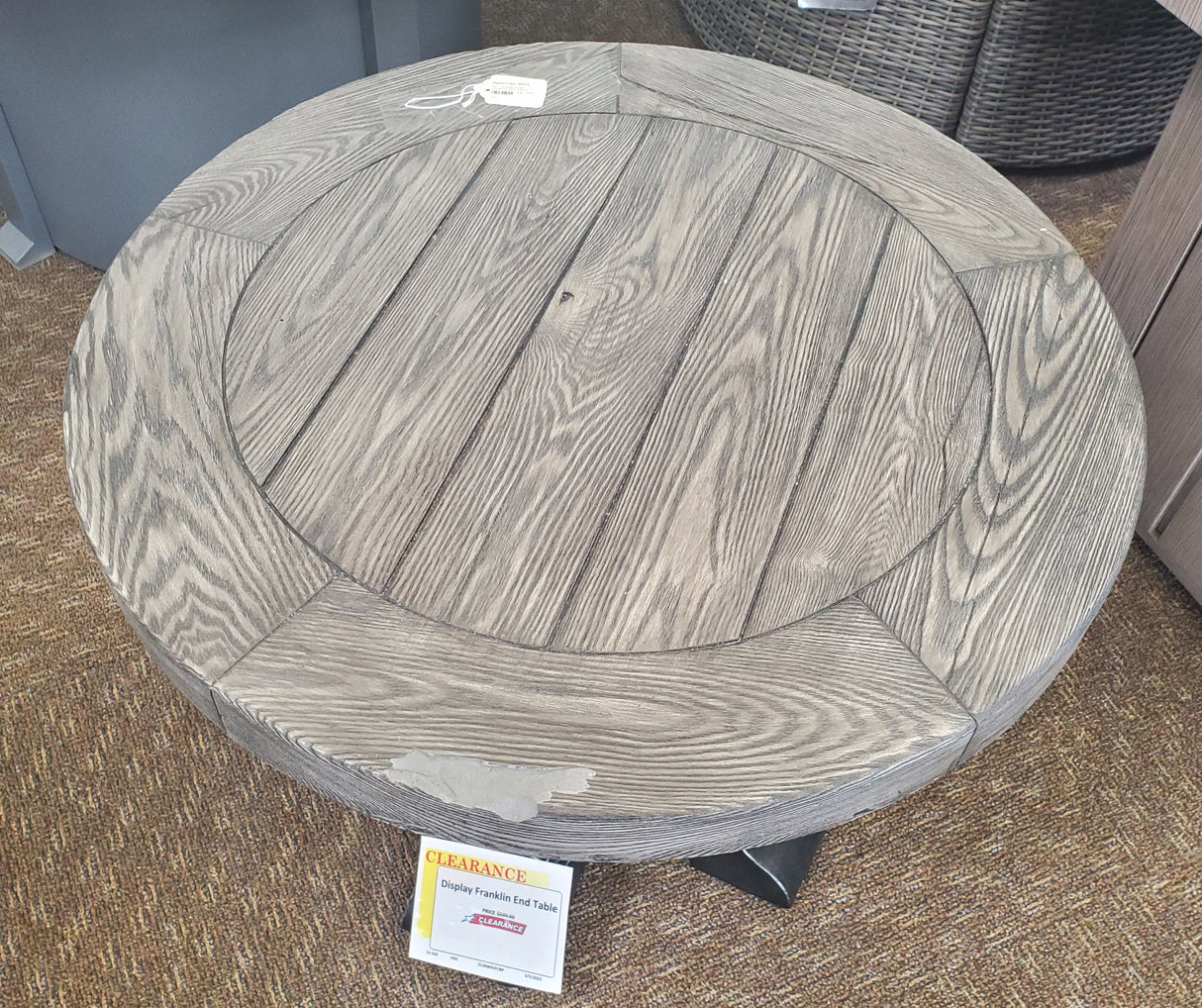 Round table with a gray woodgrain tabletop and black legs.