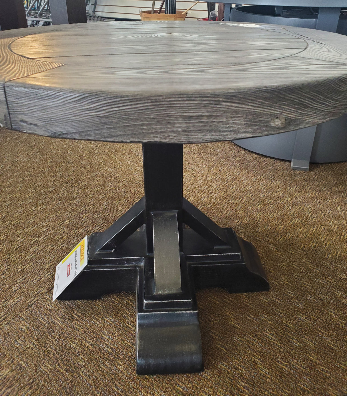 Round table with a gray woodgrain tabletop and black legs.