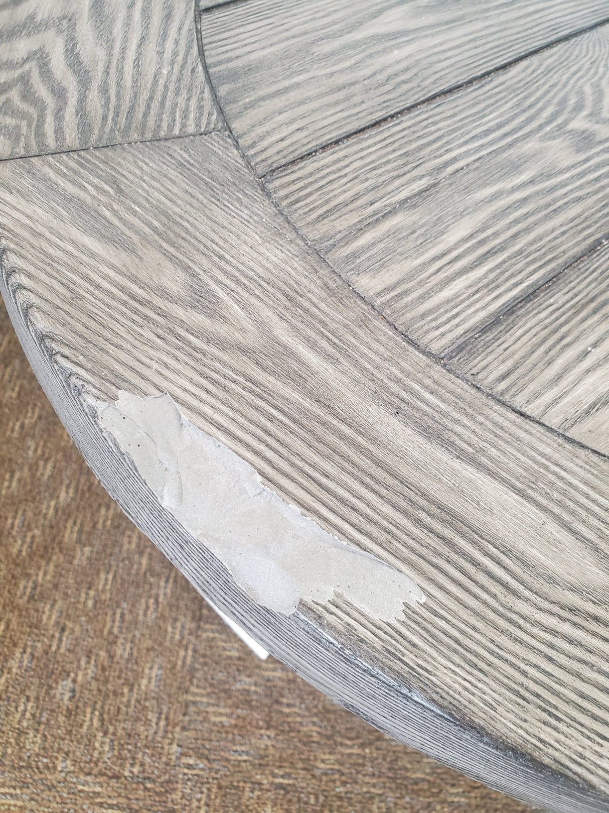 Round table with a gray woodgrain tabletop and black legs.