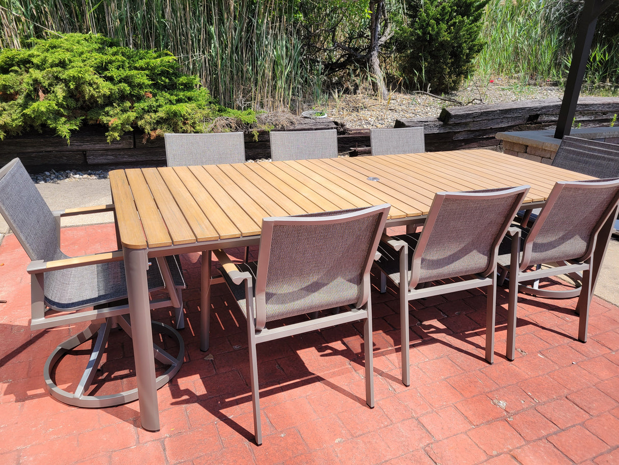This image shows a gray and wooden patio dining set on a brick patio.