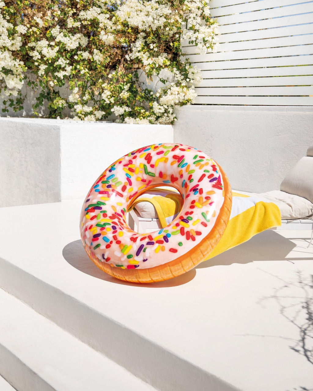 Inflatable inner tube designed to look like a donut with frosting and multi-colored sprinkles.