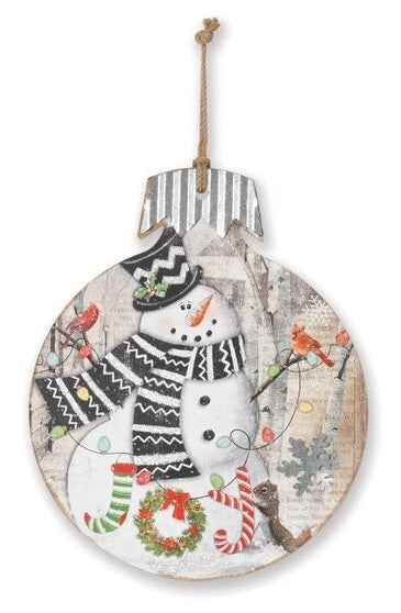 This wooden ornament features a snowman wearing a top hat and scarf with two cardinals resting on his wooden arms with a squirrel standing next to the word "Joy".
