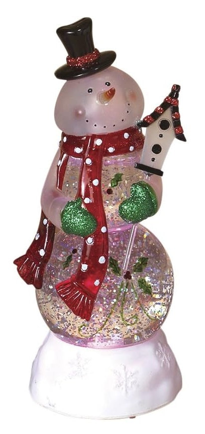 Glass snowman decoration. The snowman is wearing a black top hat, a red scarf with white polka dots and green glitter gloves. He's holding a birdhouse. There's glitter inside.