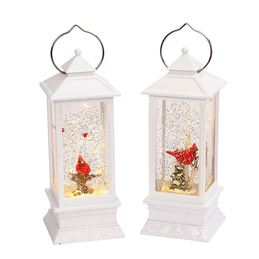 White lantern decoration with glitter and a woodland scene with a cardinal inside.