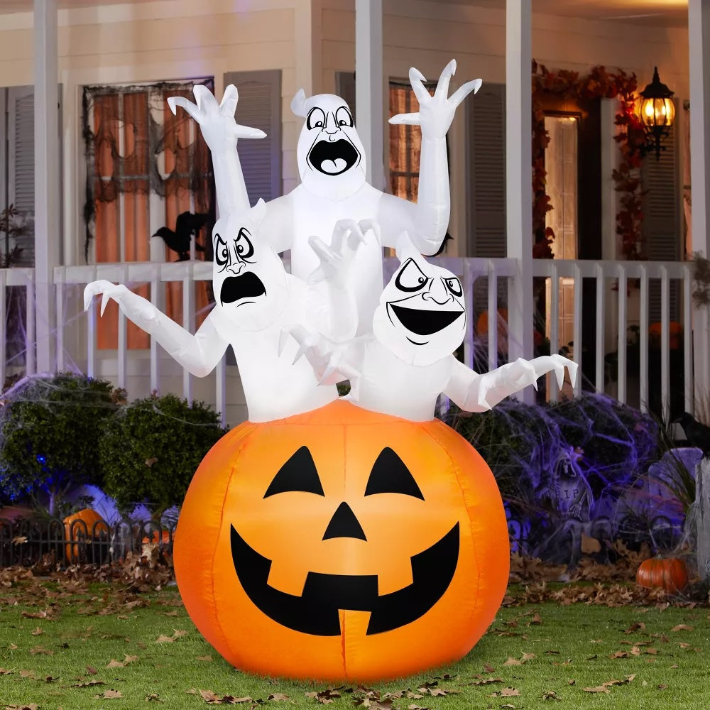Halloween inflatable shaped like three spooky ghosts jumping out of a large jack-o-lantern.