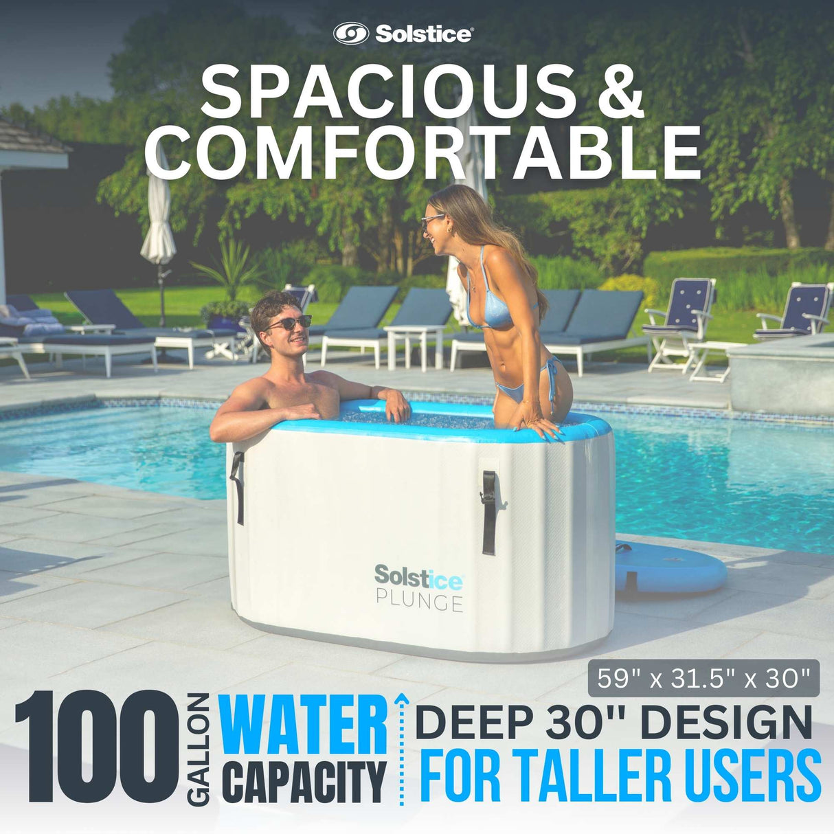This is a lifestyle image showing a man sitting in the inflatable cold plunge while a woman stands in it while they chat. It reads: "Spacious and comfortable. 100 gallon water capacity. Deep 30 inch design for taller users." It measures 59 inches by 31.5 inches by 30 inches.