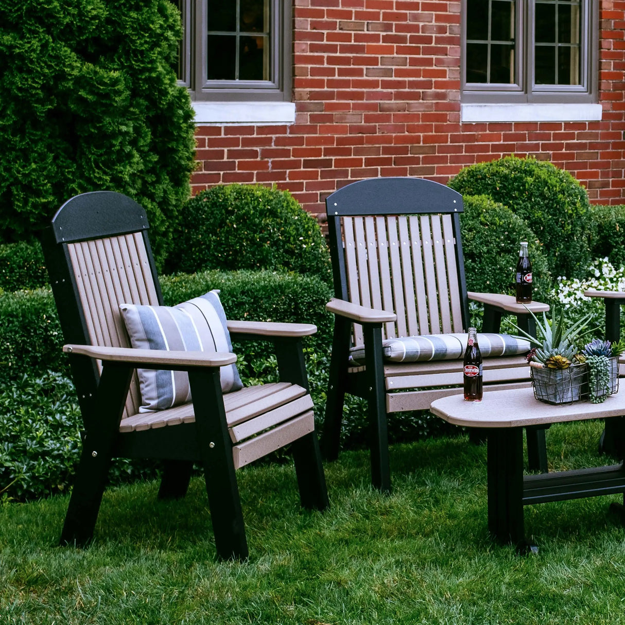 This is a lifestyle image showing two Weatherwood and Black colored benches in front of a matching table.
