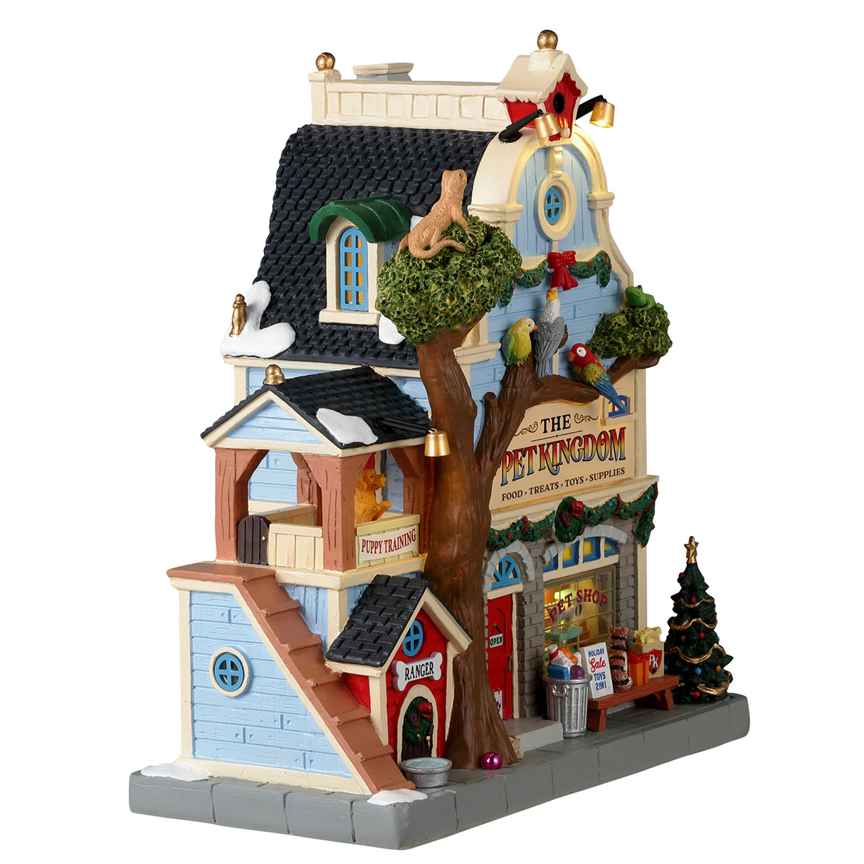Resin building for a Lemax display. Designed to look like a pet store. There's a big tree in front and features a lizard on top, three exotic birds and a dog at the base. There are dogs off to the side in the "Puppy Training" balcony. The shop is decorated for Christmas.