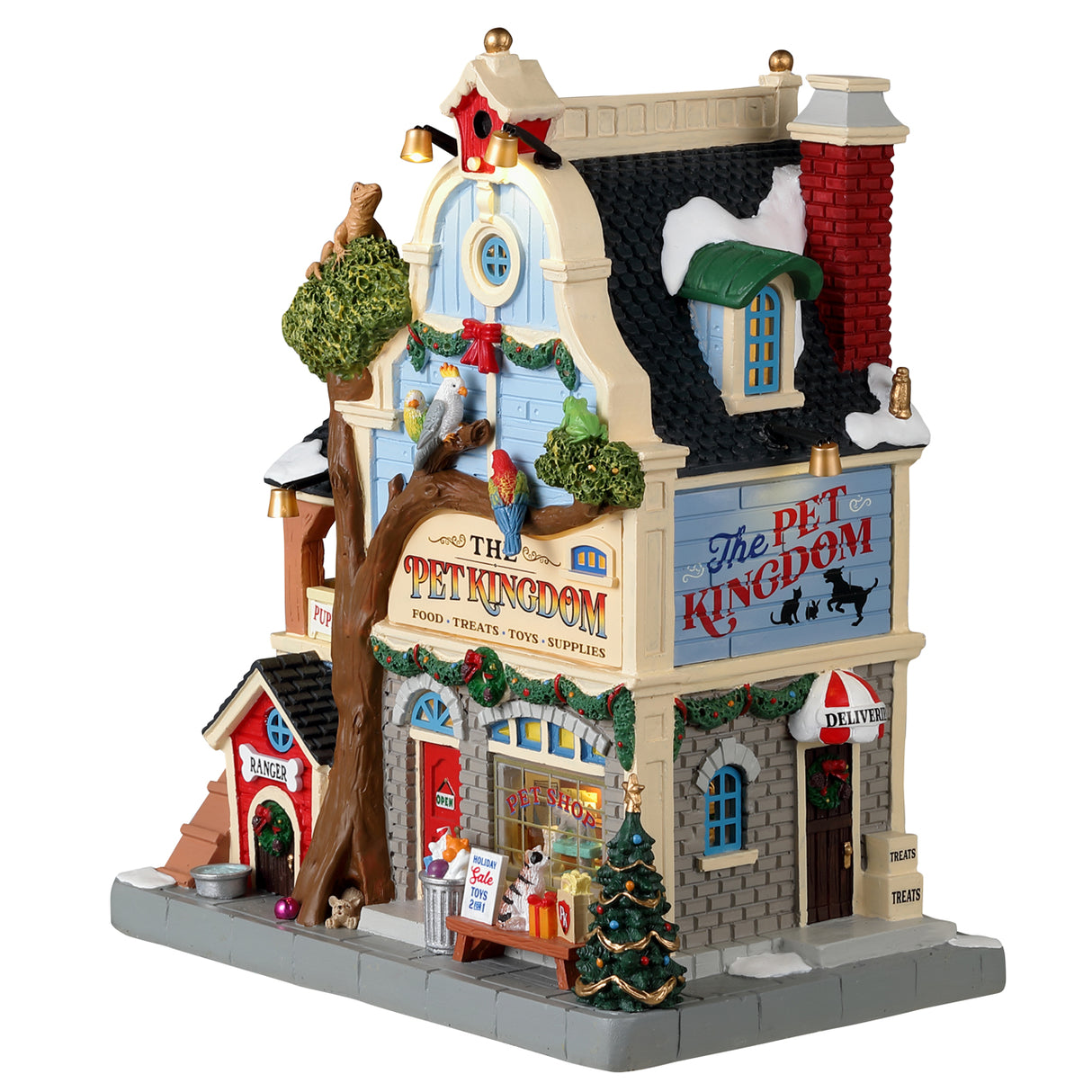 Resin building for a Lemax display. Designed to look like a pet store. There's a big tree in front and features a lizard on top, three exotic birds and a dog at the base. There are dogs off to the side in the "Puppy Training" balcony. The shop is decorated for Christmas.