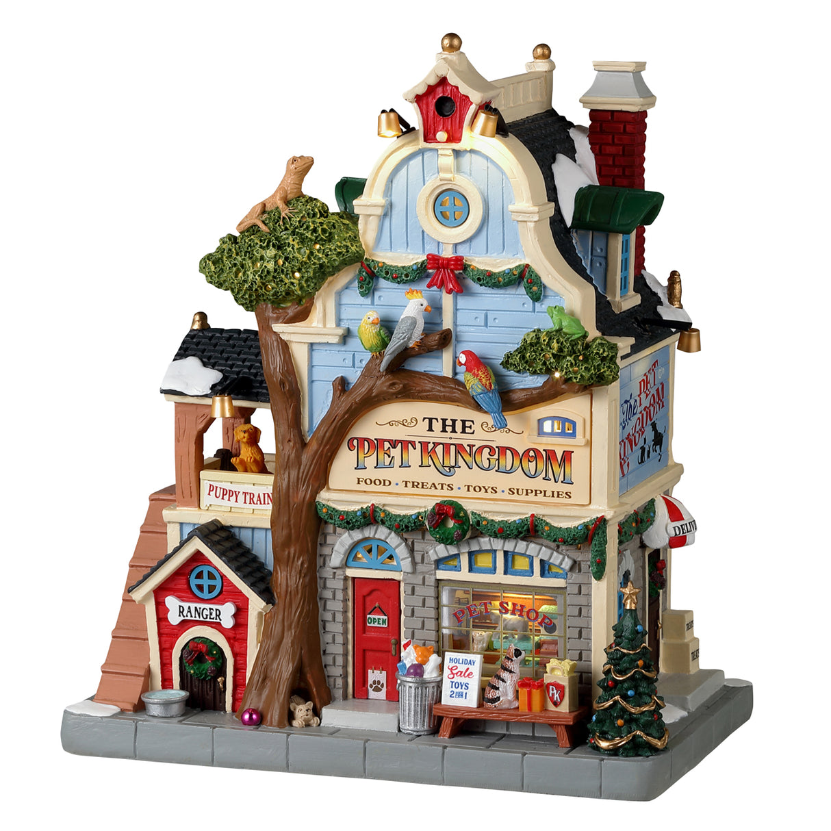 Resin building for a Lemax display. Designed to look like a pet store. There's a big tree in front and features a lizard on top, three exotic birds and a dog at the base. There are dogs off to the side in the "Puppy Training" balcony. The shop is decorated for Christmas.