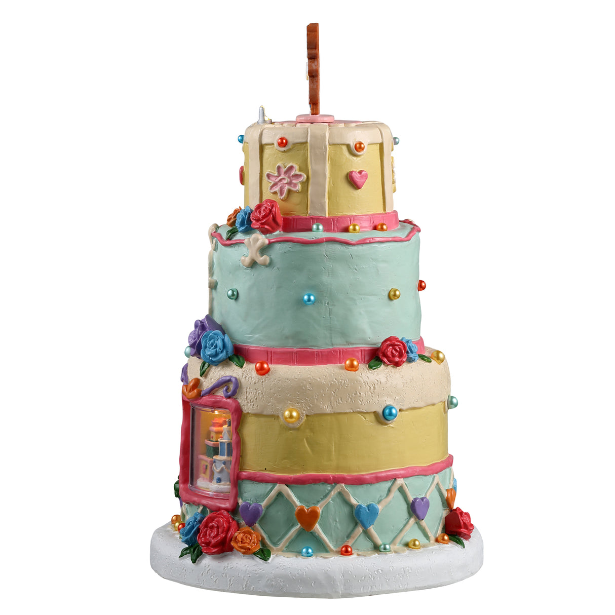 Resin lighted building for a Lemax Village display. Designed to look like a three tiered wedding cake. There's a gingerbread cookie couple on top and a cookie-shaped sign that reads "Wendy's Wedding Cakes." The top tier is yellow, the middle tier is a light teal color and the bottom tier is both yellow and light teal. There are sprinkles and frosting accents all over.