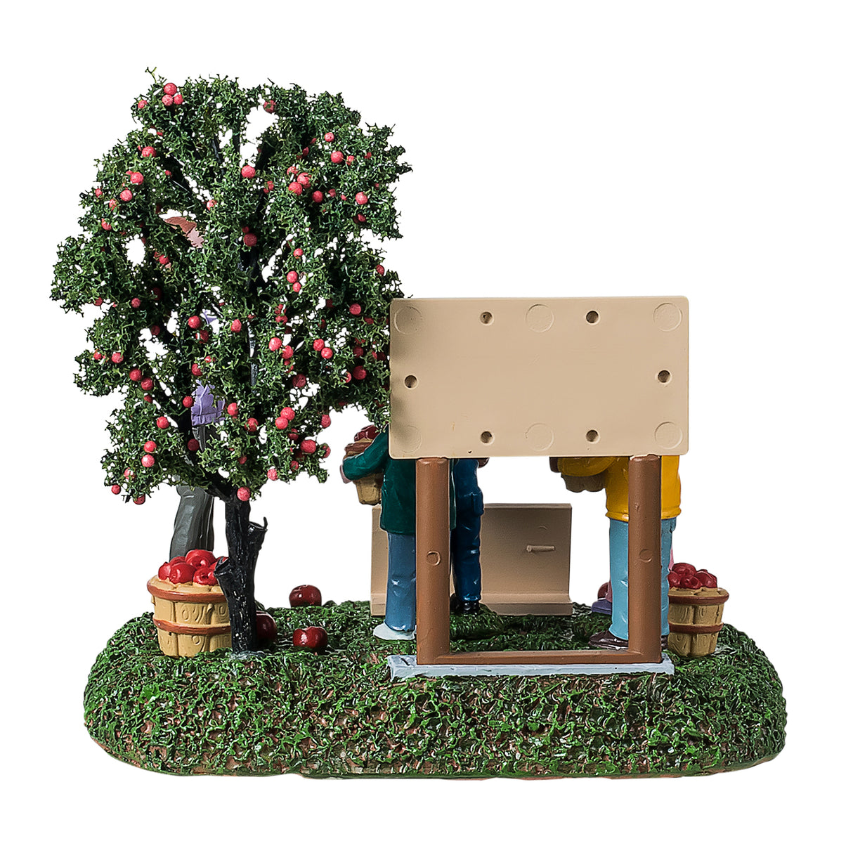 Resin table accent for a Lemax Village tabletop display. Designed to look like four students posing for a picture. They're standing next to an apple tree and a sign that reads "Annie's Apple Orchard. Pick your own farm fresh apples." The children are all smiling and holding a basket of apples. There are apples on the ground and a sign that reads "Park Hill Elementary - Mrs. Johnson's class." Mrs. Johnson is the one taking a picture of the students. The ground is covered in grass.