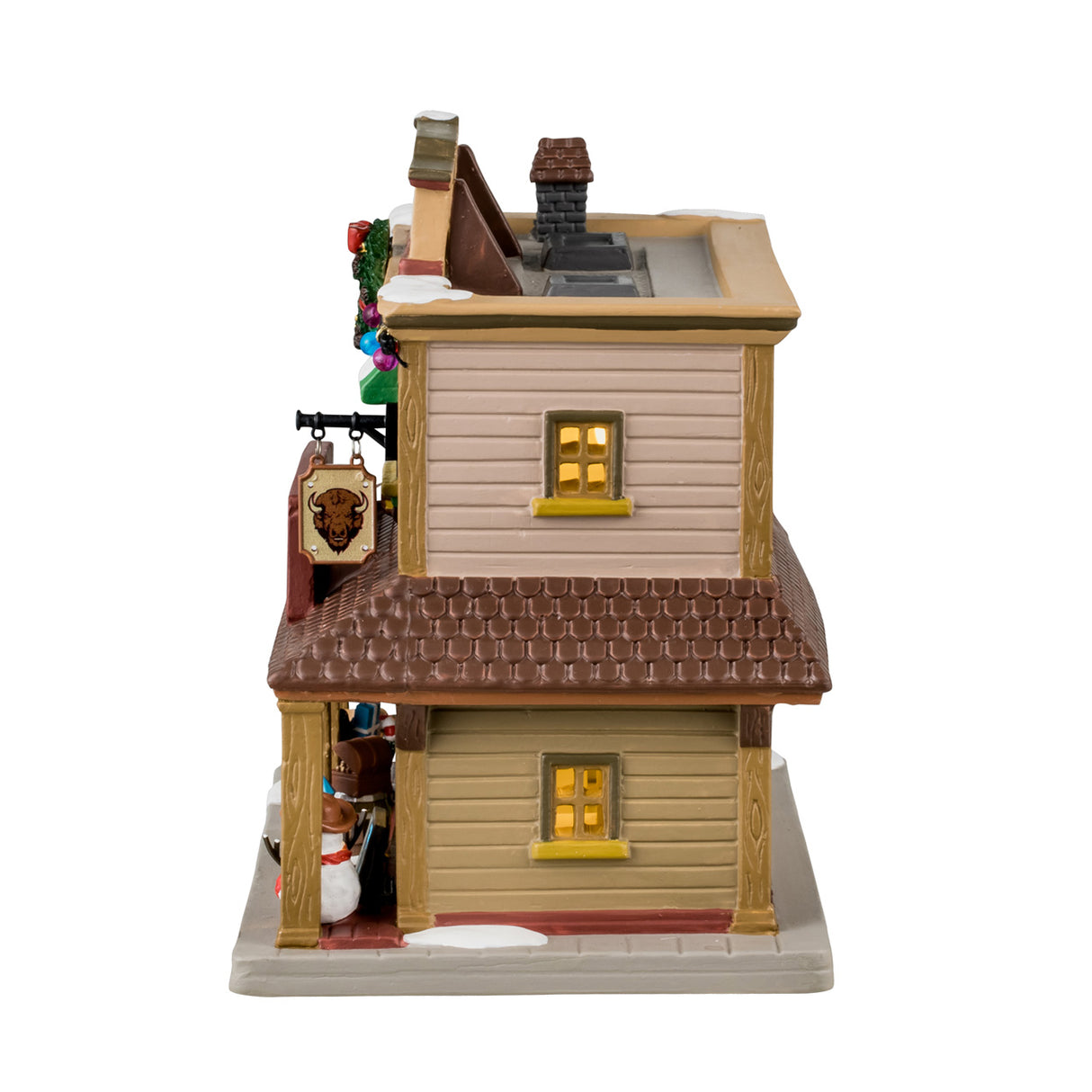 Porcelain lighted building for a Lemax display. Designed to look like a Western building. On top of the building, it says "Est. 1886." There's a large wreath near the roof and a picture of a buffalo. There's snow on the roof and a bunch of Christmas accents throughout. Accents include: a decorated Christmas tree, a Santa bag with presents and a candy cane inside, there are presents and a snowman wearing a cowboy hat.