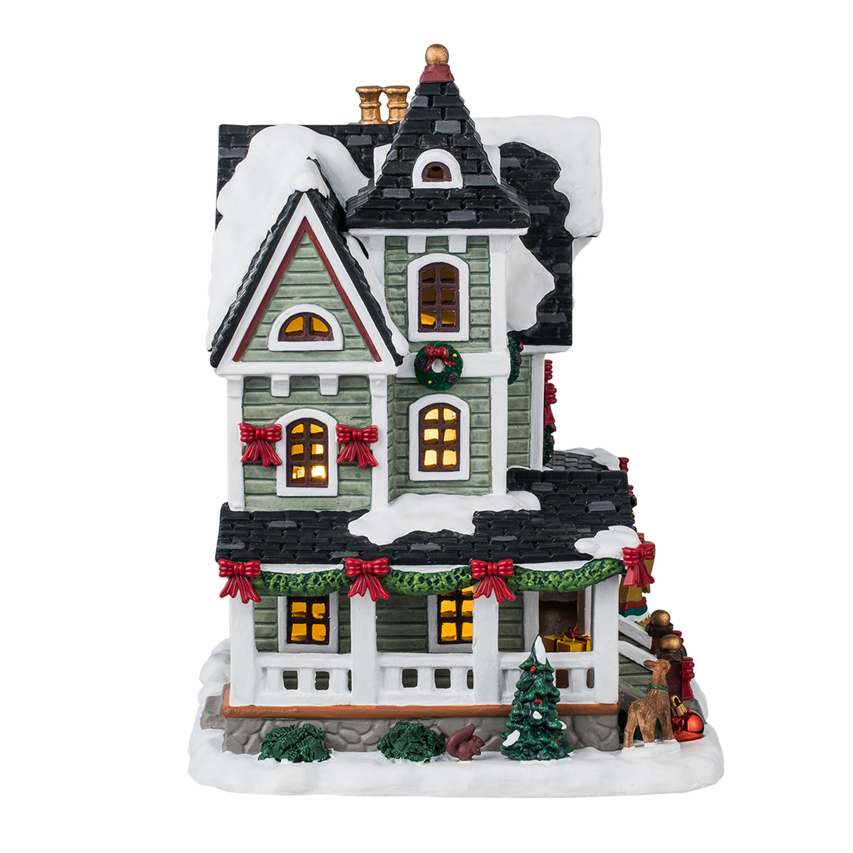 Porcelain lighted building for a Lemax display. Designed to look like a Victorian-era house covered in snow. It's decorated with decorated wreaths, garland, large shiny ornaments on the ground, Christmas trees and bushes and an angel silhouette.