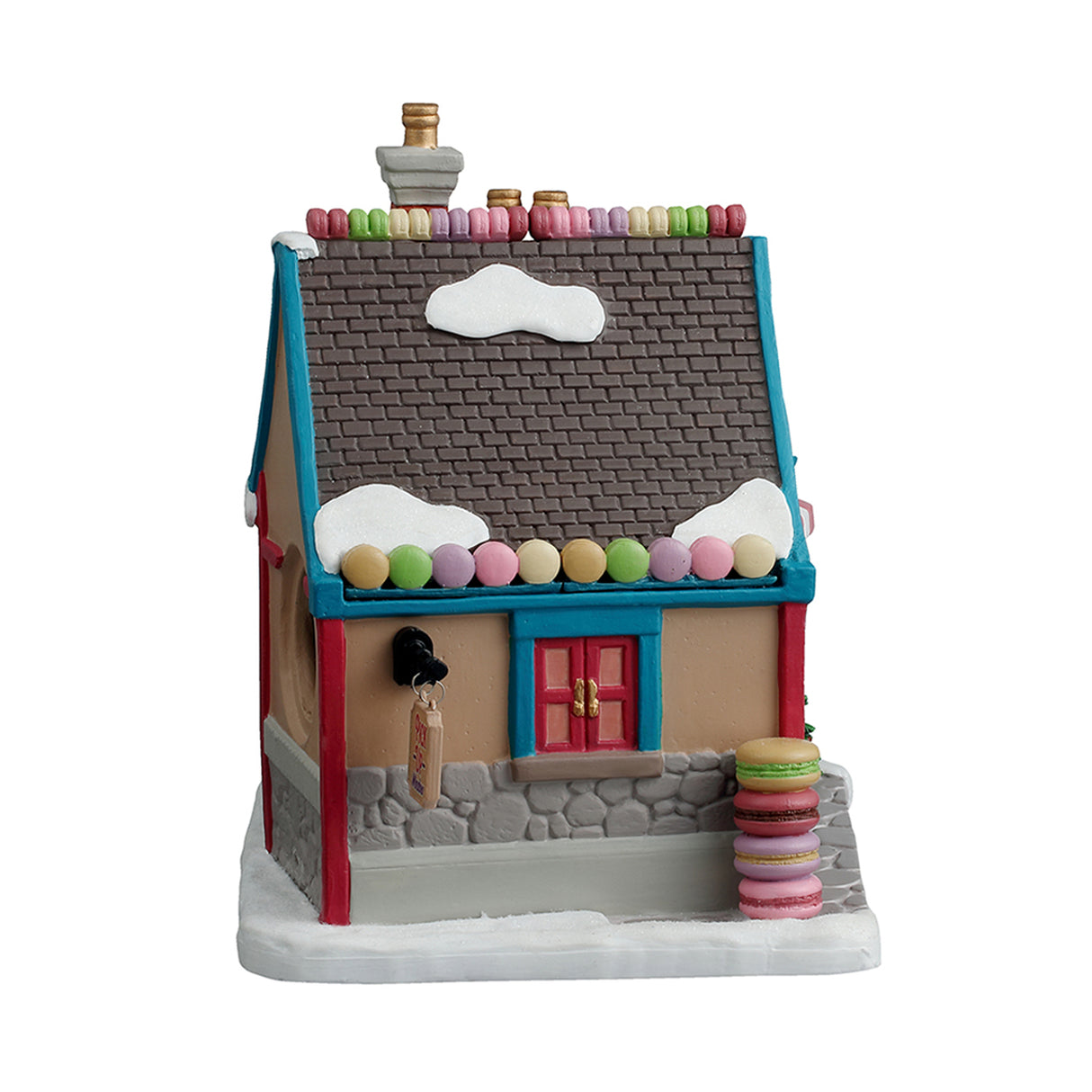 Porcelain lighted building for a Lemax display. Designed to look like a charming, little shop called Madeline's Macaroons French Pastries. Inside the window, you can see a display of macaroons. There are decorated wreaths, garland and a Christmas tree. There's snow on the ground and on the roof. There are also candy accents on the roof and macaroons on the sidewalk.