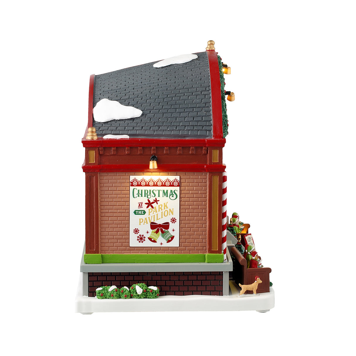 Resin lighted building for a Lemax display. Designed to look like a choir performing at a pavilion. There's a large organ, kids dressed like elves, two dogs, two peppermint candy cane accents, a decorated garland on the roof and a sign that reads "Joy to the World." The ceiling of the pavilion is decorated with different colored poinsettias.