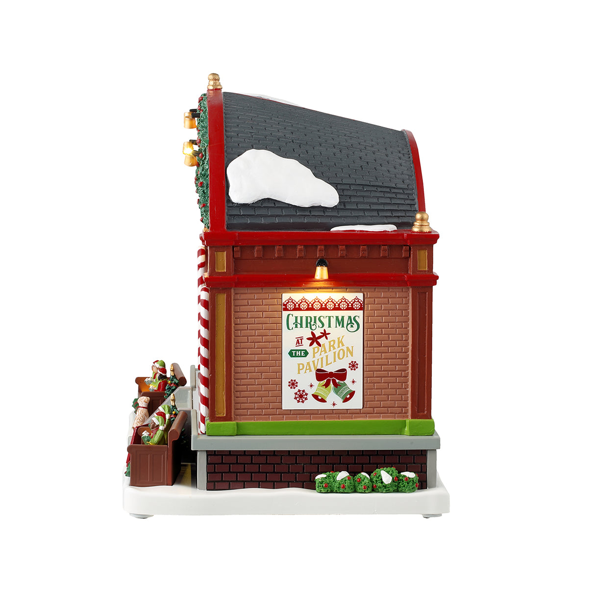 Resin lighted building for a Lemax display. Designed to look like a choir performing at a pavilion. There's a large organ, kids dressed like elves, two dogs, two peppermint candy cane accents, a decorated garland on the roof and a sign that reads "Joy to the World." The ceiling of the pavilion is decorated with different colored poinsettias.