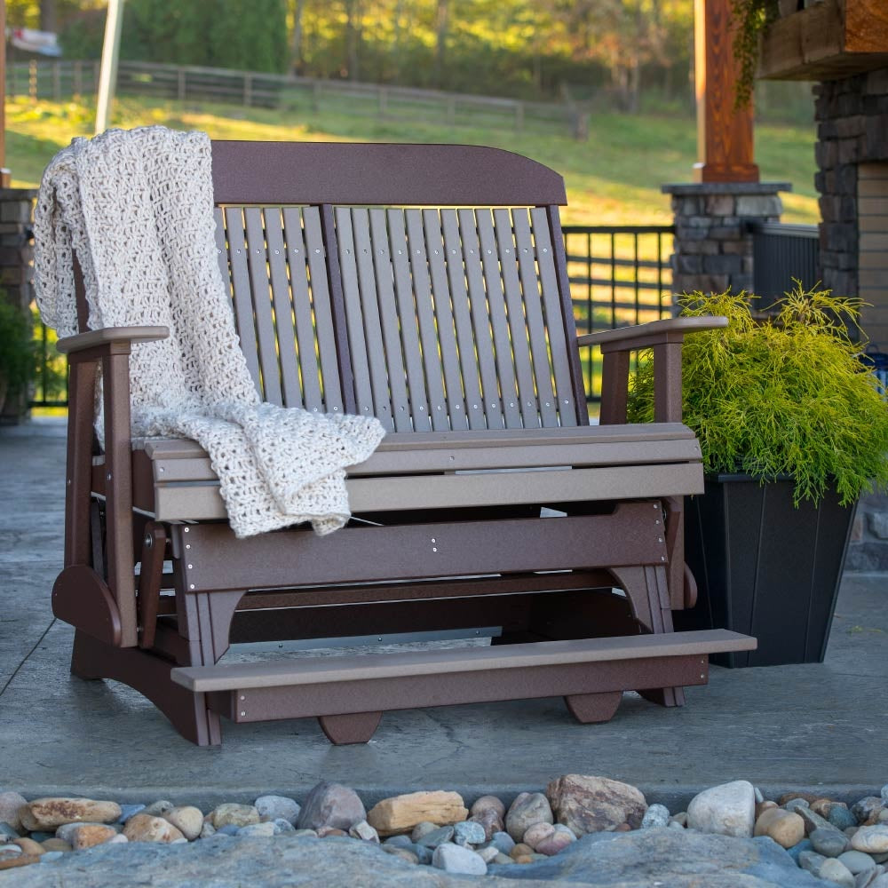 This is the Weatherwood and Chestnut Brown colored classic balcony glider bench with a blanket draped off on the side.