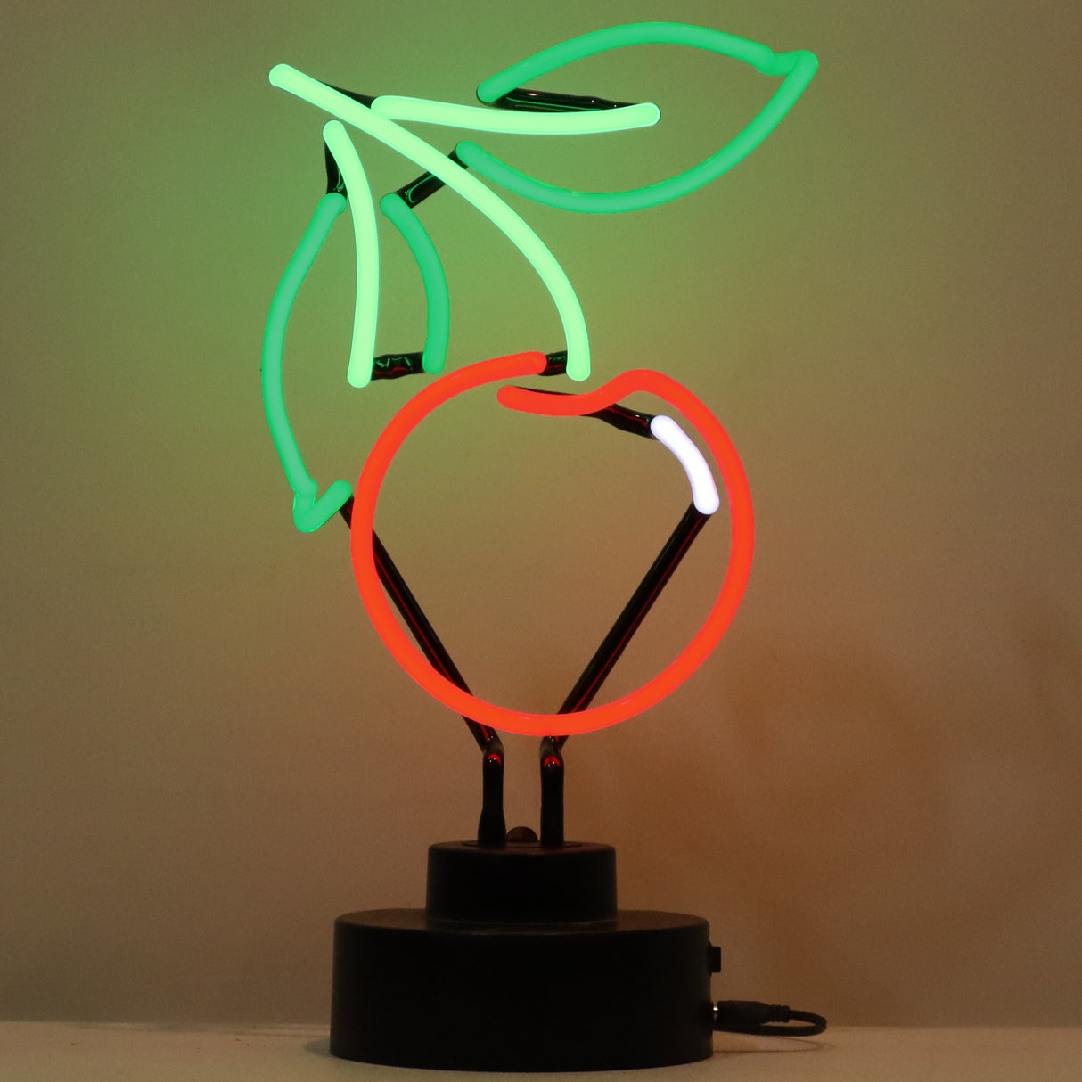 This neon sculpture is shaped like a red cherry with a green stem and two green leaves.