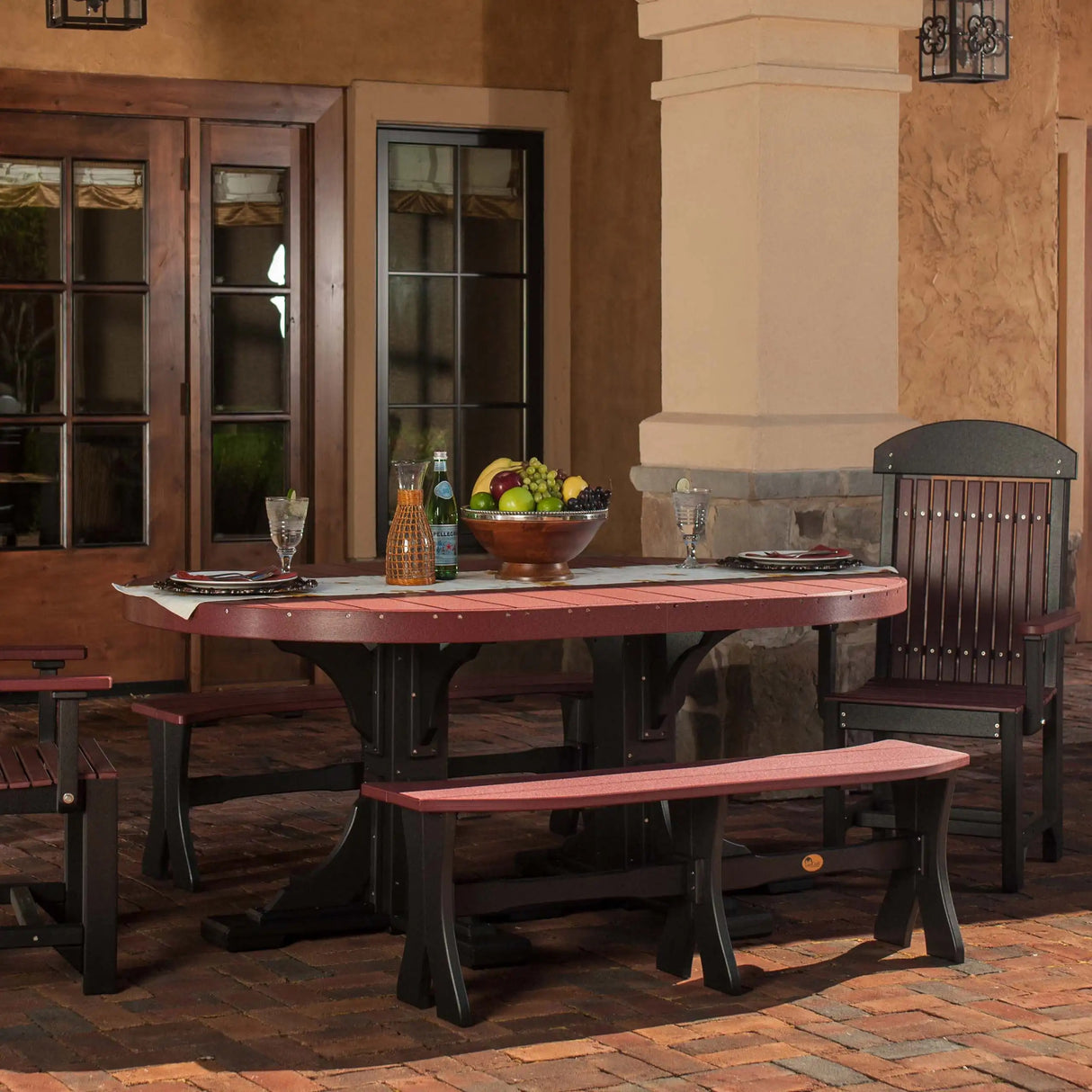 This is a lifestyle image that shows the Cherrywood and Black colored oval dining table with matching benches and chairs.