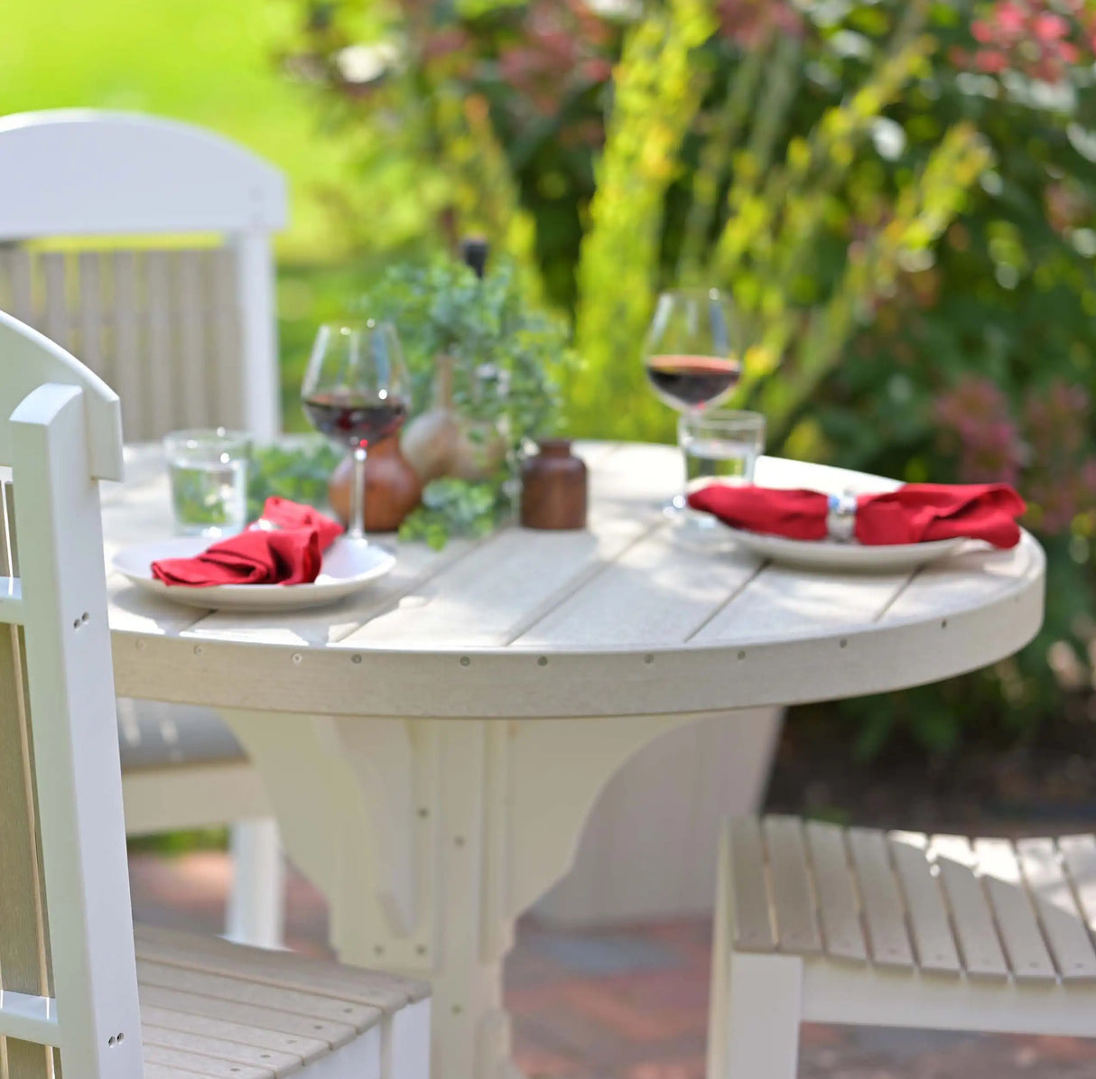 This is a lifestyle image showing the table up close. There are plates and napkins and full wine glasses on the table.