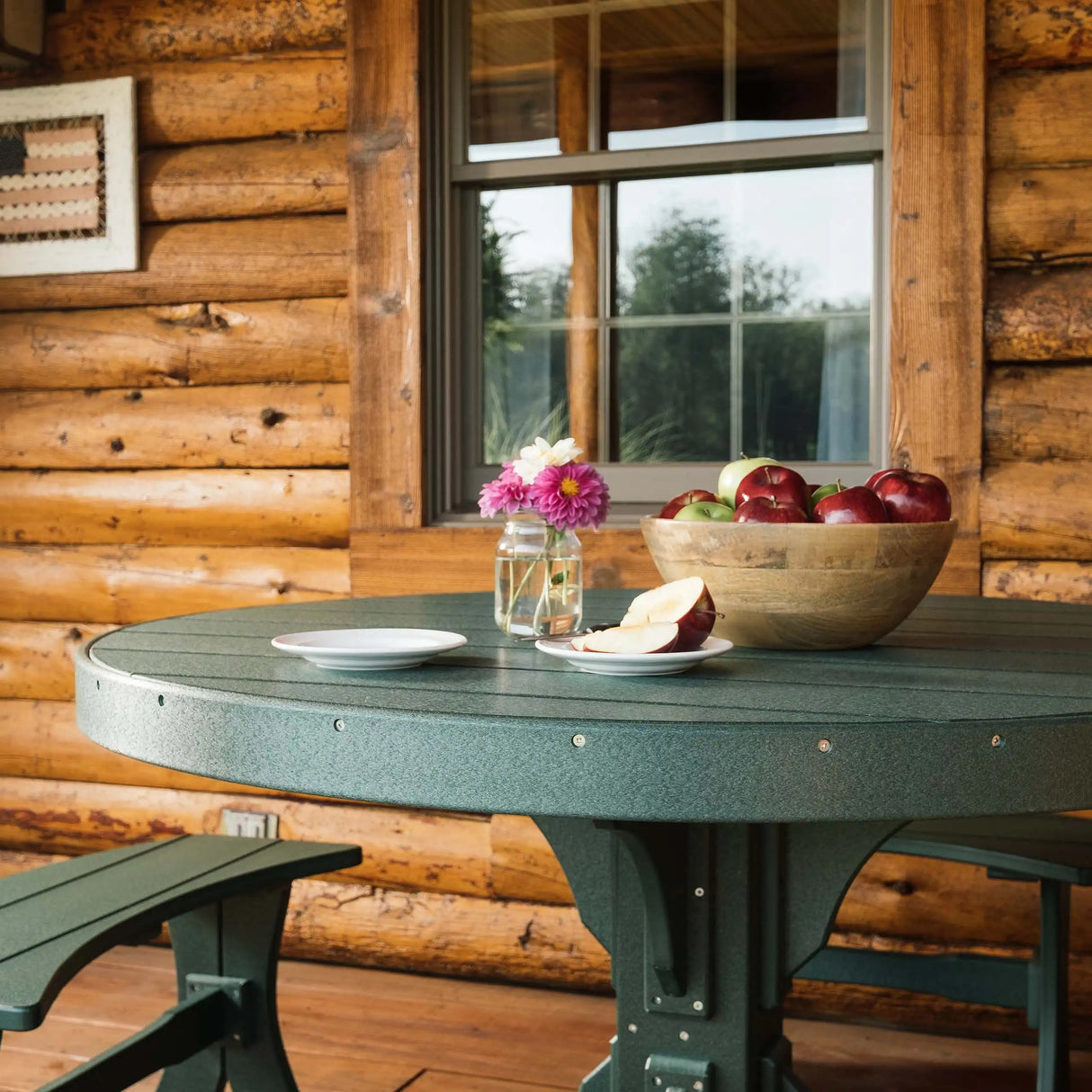 This is a lifestyle image showing the Green table outside of a cabin.