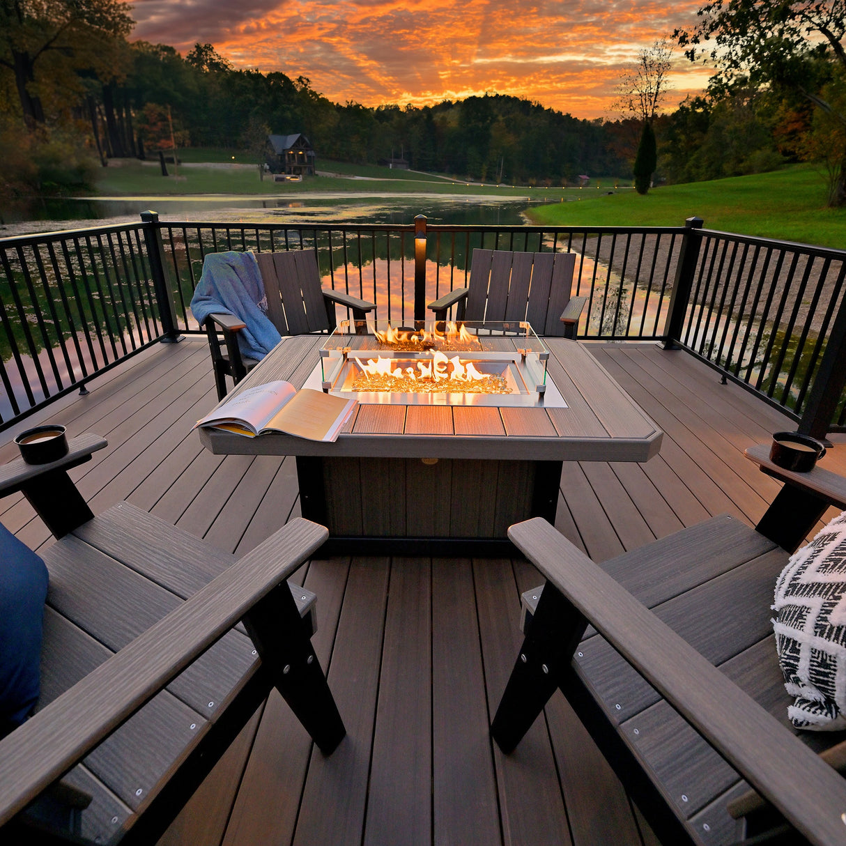 This is a lifestyle image showing the Coastal Gray and Black colored rectangular fire pit table on a matching porch at sunset.
