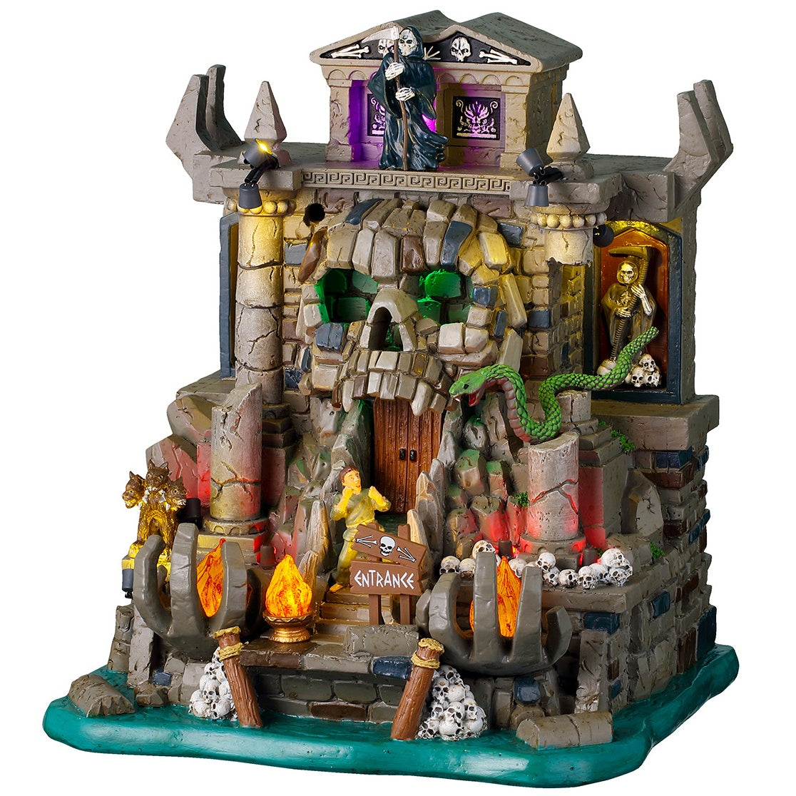 This image shows what this Lemax Spooky Town lighted building looks like on a white background. It was designed to look like a stone and brick cave shaped like a skull in some water. The front door is in the skull's mouth. There's a Grim Reaper standing up top. There are skulls and bones and fires and snakes.