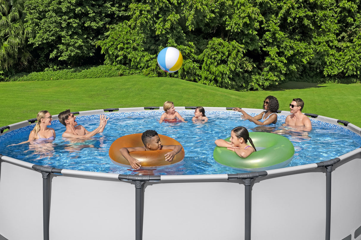This image shows a pool with four adults playing with a beach ball, two kids chatting and two kids floating in inner tubes.