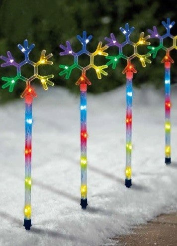 Pathway markers shaped like snowflakes. Pre-lit with LED lights that are controlled by an app.