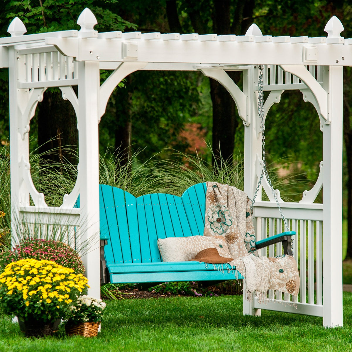 This is a lifestyle image showing the Aruba Blue and Black colored Adirondack swing hanging from a white gazebo in a grassy backyard.