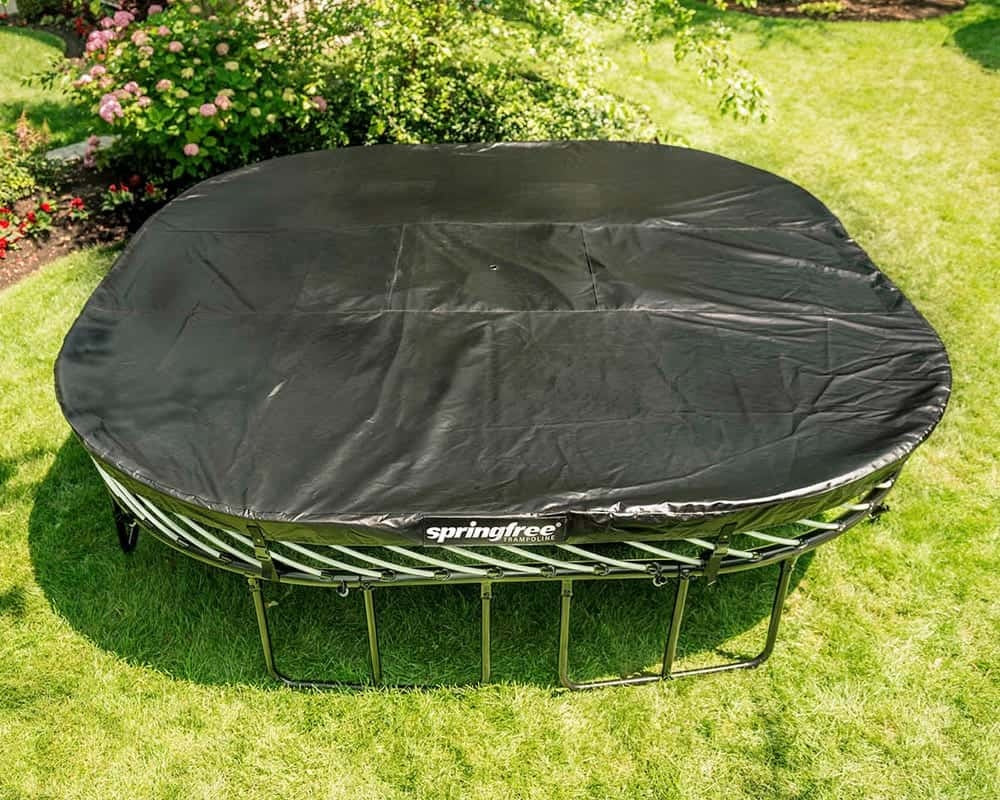 This is a lifestyle image showing the cover on this jumbo square trampoline in a grassy backyard.