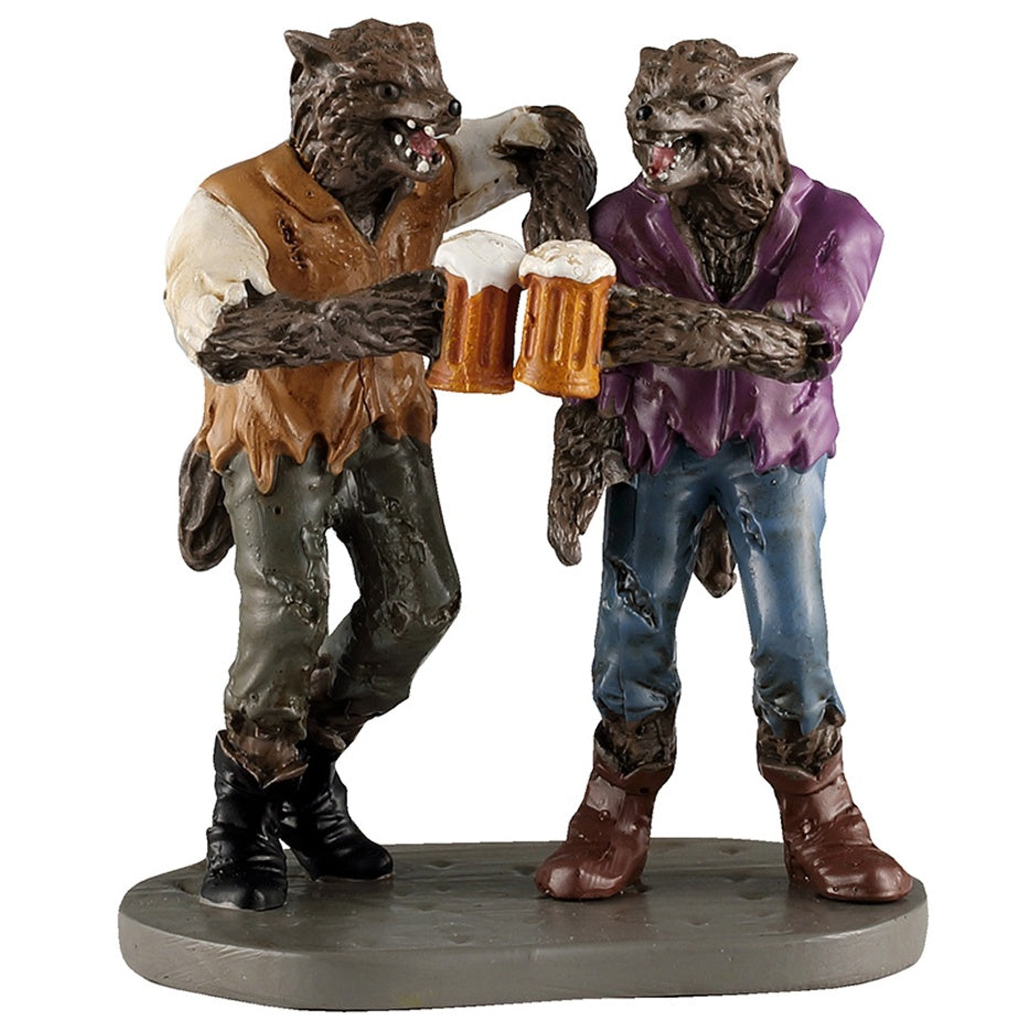 This image shows what this Lemax Spooky Town figurine looks like on a white background. It was designed to look like two werewolf buddies clinking their mugs of beer together in celebration. The werewolf on the left is wearing a dirty white shirt with a brown, tattered vest along with gray jeans with holes in them and black cowboy boots. The werewolf on the right is wearing a purple jacket, tattered blue jeans and brown cowboy boots.