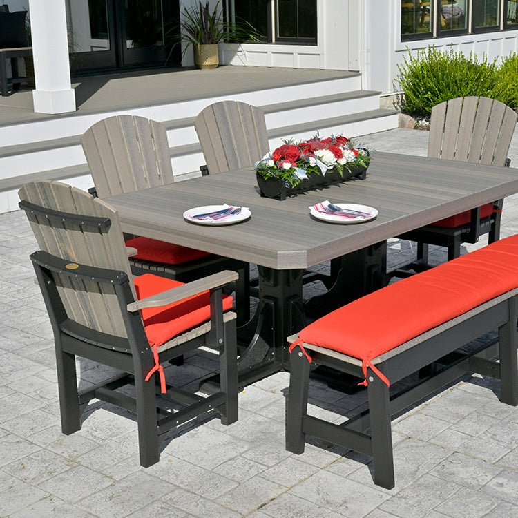 This is a lifestyle image showing the Coastal Gray and Black colored table with matching chairs and benches on an outdoor patio. The chairs and the benches have bright red cushions on them.