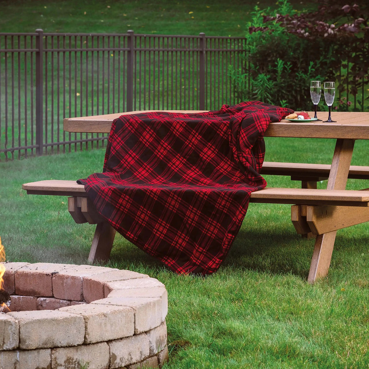 This is the Antique Mahogany colored picnic table with a red and black buffalo check blanket draped over the side.