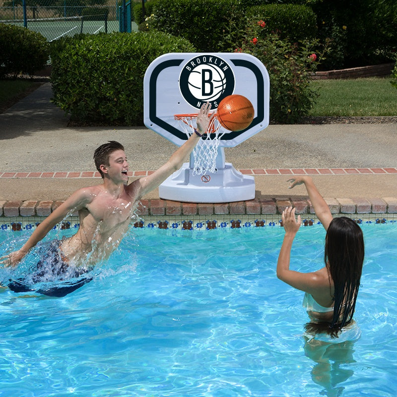This is a lifestyle image showing two people playing basketball in the pool, aiming the ball for the Brooklyn Nets themed basketball hoop.