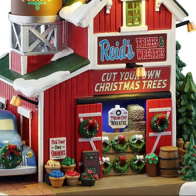 This is an up close view of the building. There are buckets of tree ornaments and bouquets of flowers on the sidewalk.