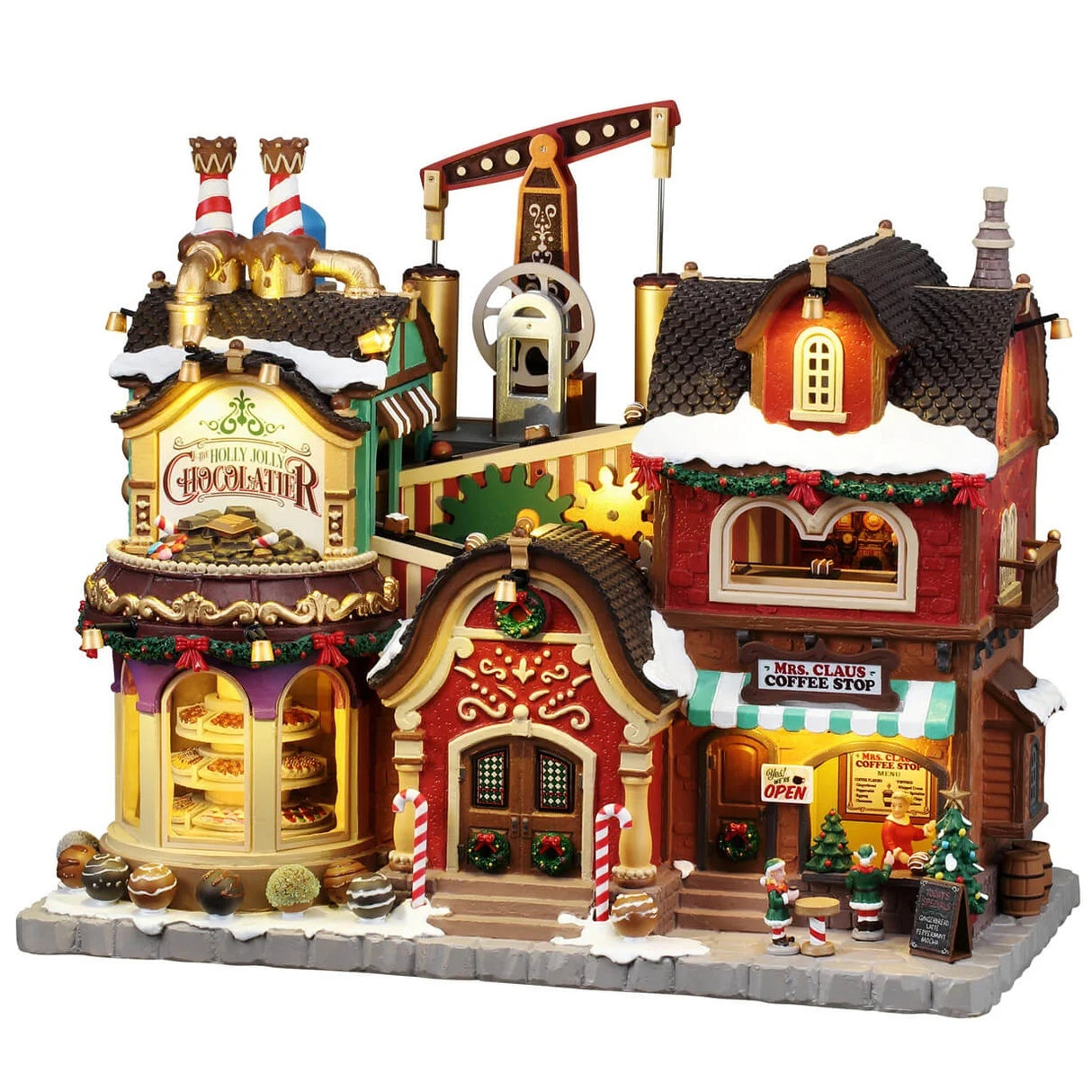This image shows what this Lemax building looks like on a white background. It was designed to look like one building that has been split into two shops: The Holly Jolly Chocolatier and Mrs. Claus' Coffee Shop. There are windows at the chocolate shop and you can look in and see all the different candies on display. The whole building is decorated with wreaths and garlands and candy cane accents. At the coffee shop, there's a woman working behind the counter and some elves outside helping.