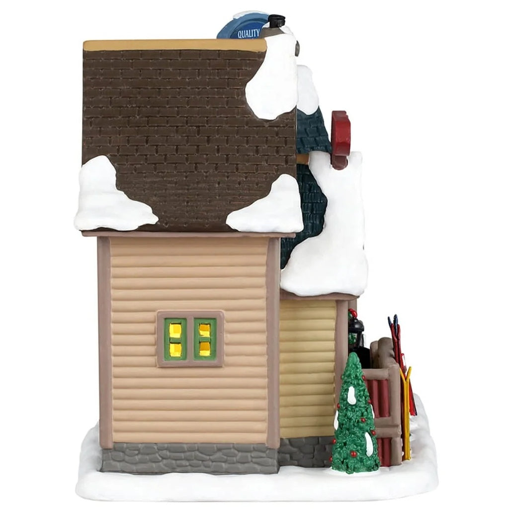 This image shows the other side of the building. The roof, ground and trees are covered in snow.