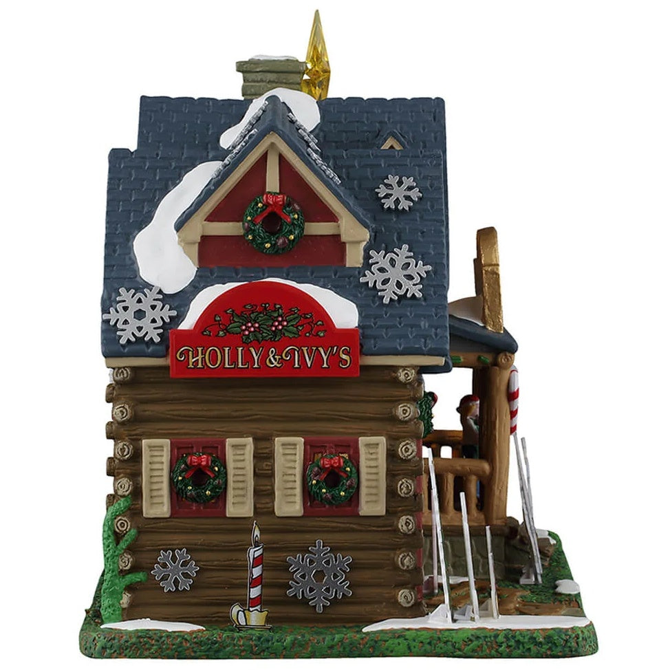 This image shows what this side of the building looks like. There are decorative snowflakes all over, as well as decorated wreaths. There's a big red sign that reads "Holly & Ivy's."