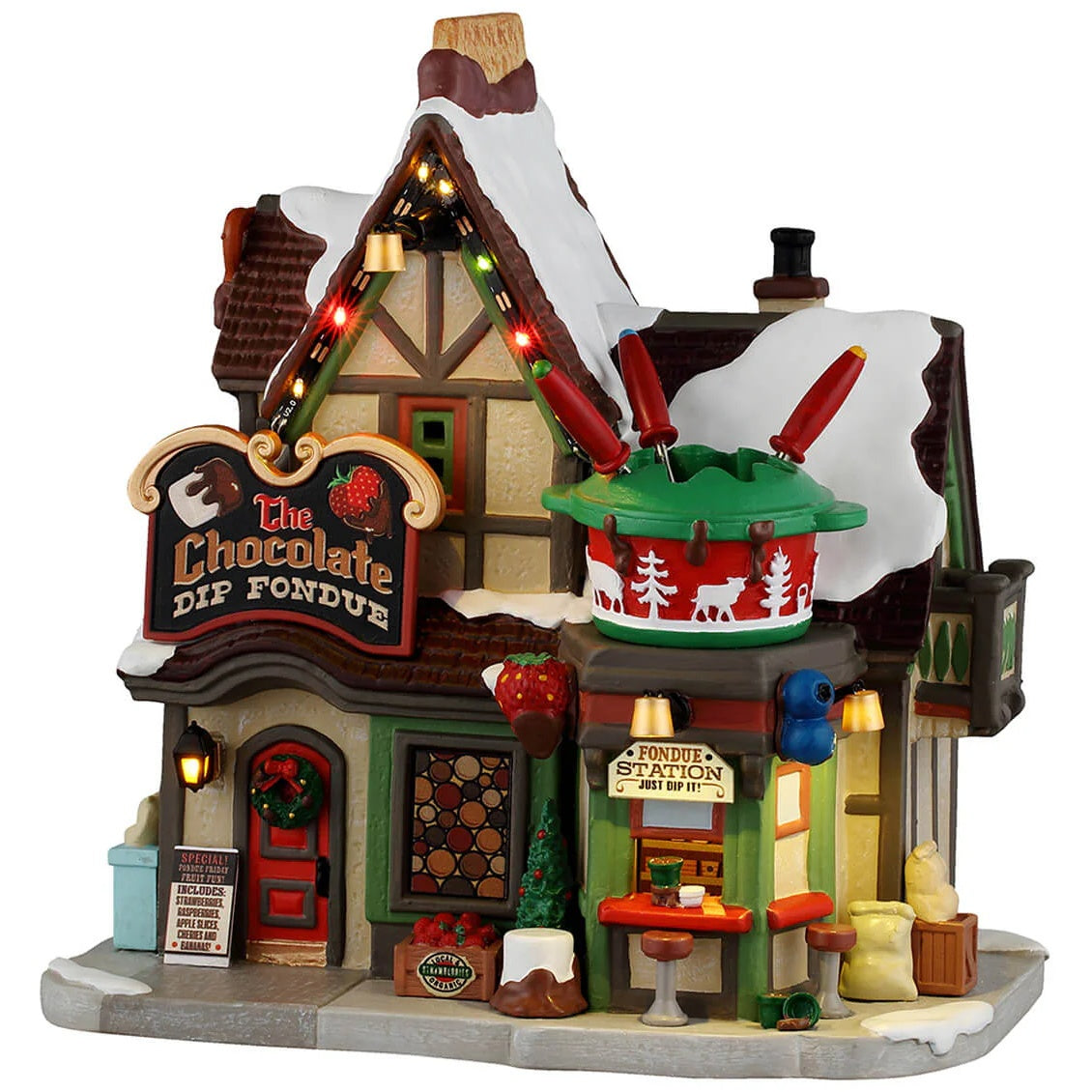 This image shows what this Lemax Vail Village lighted building looks like on a white background. It was designed to look like a cottage turned into a restaurant. On the roof, there's a large, fake fondue pot. There's a fondue station booth on the sidewalk.