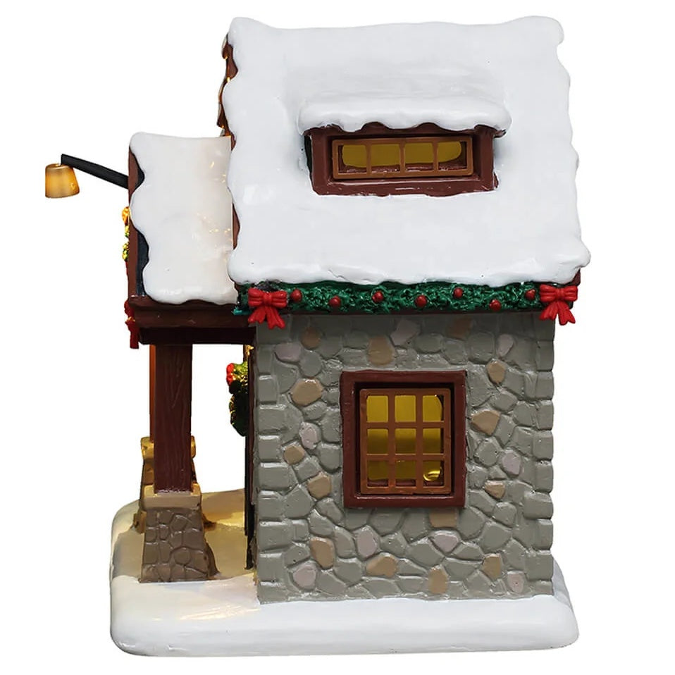 This image shows what the side of the house looks like. You can see the green garland with red bows along the roofline and a window.