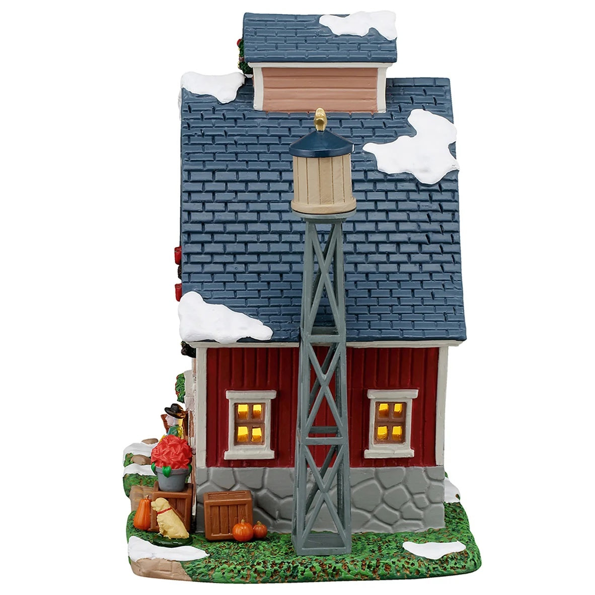 This image shows what the side of this building looks like. There's a water tower standing next to the house. There's some snow on the roof and on the grass.