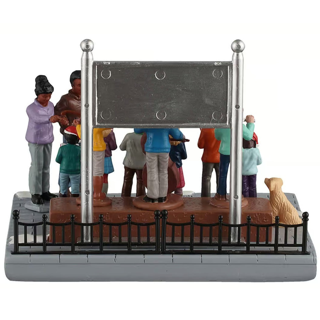 This image shows what this table piece looks like from the back. The sign behind them is silver on the back. There's also a small golden retriever dog watching from the side.