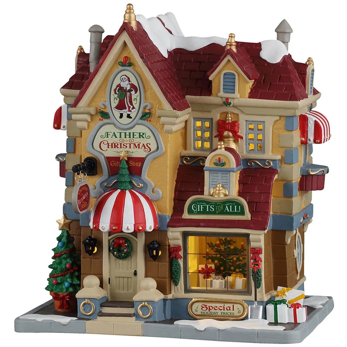 This image shows what this Lemax building looks like on a white background. It was designed to look like a tall Christmas shop. There's snow on the roof and on the sidewalk. There are decorated wreaths, trees and red bows. There are some wrapped presents on the ground near the front window.