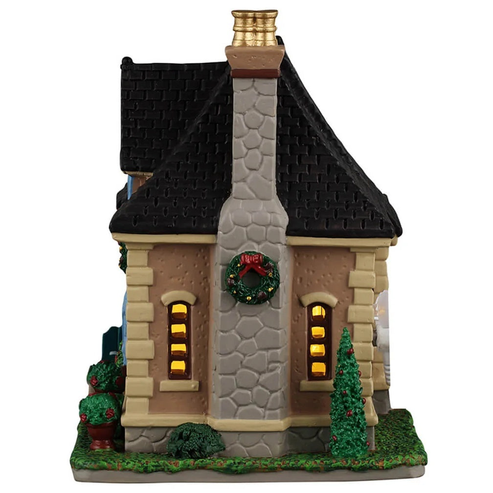 This image shows what the other side of this building looks like. There's a tall, stone chimney with a wreath on it.