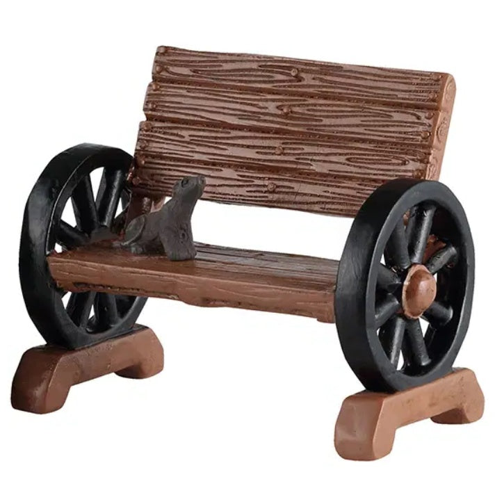 This image shows one of the wooden benches with the wheel armrests. This one has a gray rat sitting on it.